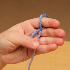 Hand holding yarn for finger knitting 