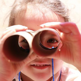 Child looking through cardboard binoculars 