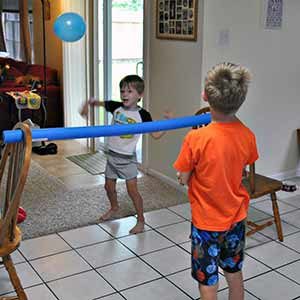 Kids playing balloon volleyball at home 