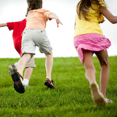 three kids running in grass