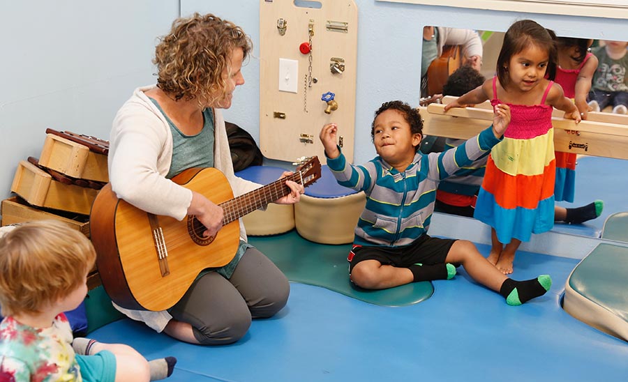 guitarsing Brooke Chabot plays guitar for a sing along with young children